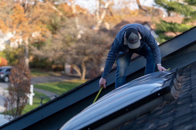 Joey Sayre of Roof Revivers, measures a skylight for replacement in Columbus, Ohio.